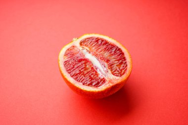 Kırmızı arka planda sulu kan portakalı ve yoğunlaştırılmış süt. Seks konsepti 18+