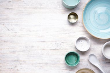 Modern seramik ve ahşap çanak çömlek, yazı için yeri olan moda sofra takımı. Ahşap bir arka planda yemek servis etmek ve yemek yemek için tabaklar, üst manzara. 