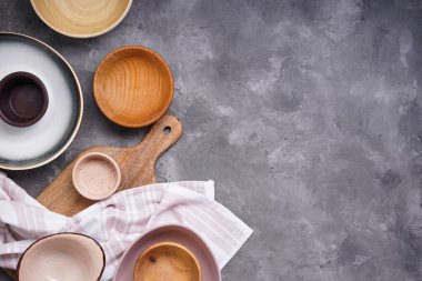 Modern seramik ve ahşap çanak çömlek, moda sofra takımı. Gri arkaplanda yemek servisi ve yemek için tabak, metin için yer, üst görünüm. 