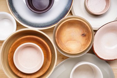 Modern seramik ve ahşap çanak çömlek, moda sofra takımı, yakın çekim. Ahşap bir arka planda yemek servis etmek ve yemek yemek için tabaklar, üst manzara. 