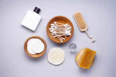 Spa konsepti. Gri arka planda pamuk pedler ve kişisel bakım ürünleri, üst görünüm. 