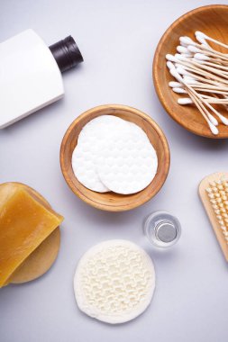 Spa konsepti. Gri arka planda pamuk pedler ve kişisel bakım ürünleri, üst görünüm. 