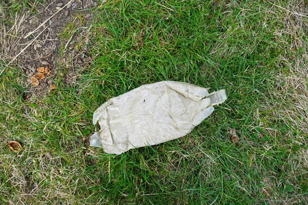 A pile of rubbish in a clearing in the countryside on a spring day, top view. Concept of ecology. Plastic bottle.