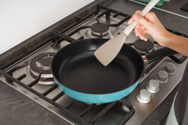 Frying pan on a gas stove, preparing to cook in the kitchen.