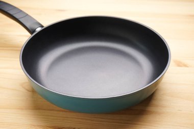 Ahşap arka planda yeni kızartma tavası, yakın plan..