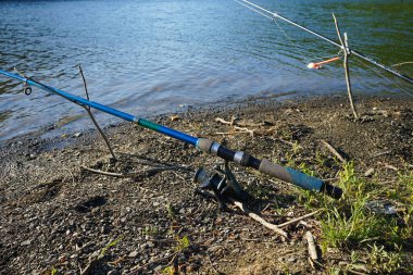 Fishing rods and fishing tackle on the river bank, close-up.
