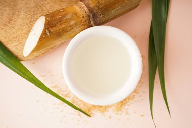 Fresh cane juice and brown sugar on a beige background. Top view.