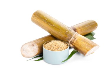 Sugar cane and brown sugar on white isolate background. Close-up.