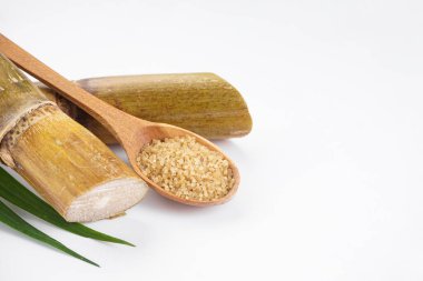 Sugar cane and brown sugar on white background with space for text. Close-up.