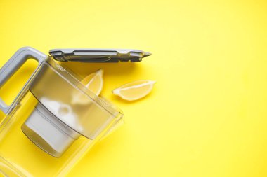Sarı arka planda limonlu su filtresi. Üst görünüm.