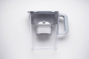 Gri arkaplanda kartuş bulunan su filtresi sürahisi, üst görünüm.