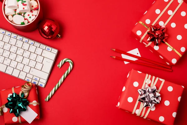Arbeitsbereich Mit Tastatur Und Weihnachtsgeschenk Und Zuckerrohr Auf Rotem Hintergrund Stockbild