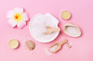 Deniz tuzu kristalleri deniz tuzu ve deniz pembesi arkaplan manzaralı küçük tahta kepçesi şeklinde beyaz kasede.