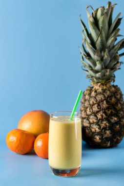 Taze Harmanlanmış Sarı ve Portakal Meyveli Buzlu Smoothie ile Saman Ananas ve Citrus Smoothie Sağlıklı Mavi Arkaplan