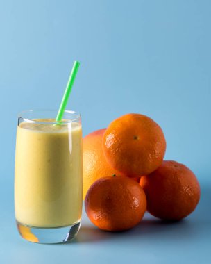 Taze Harmanlanmış Sarı ve Portakal Meyveli Buzlu Smoothie ile Saman Ananas ve Citrus Smoothie Sağlıklı Mavi Arkaplan