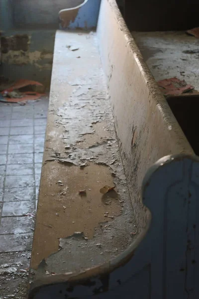 Terk edilmiş bir binada tozlu kilise sıraları.