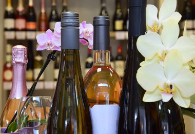 Masada çiçekli birkaç şişe beyaz ve pembe şarap. Şenlik havası. Kutlama zamanı..