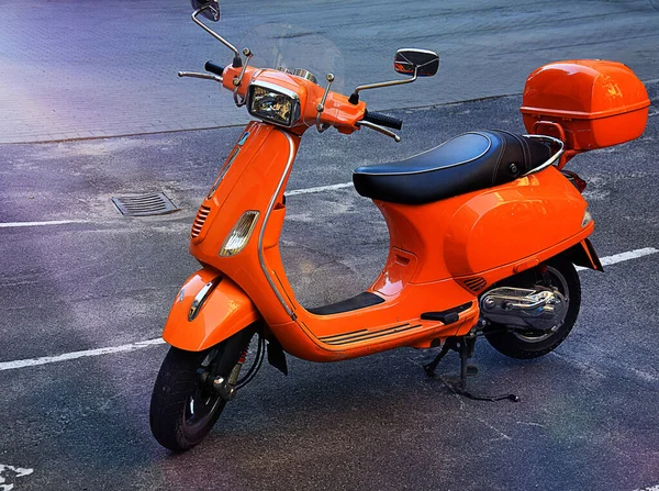 The retro orange classic scooter motor on street of city