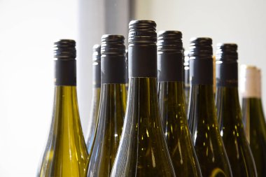 Güneşte parlayan şarap şişeleri, şarap dükkanında şarap şişeleri ve eve teslim için hazır.