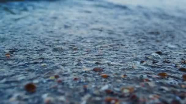 Macro azul agua de mar salpicando playa de arena de concha marina en cámara lenta. Olas marinas — Vídeos de Stock