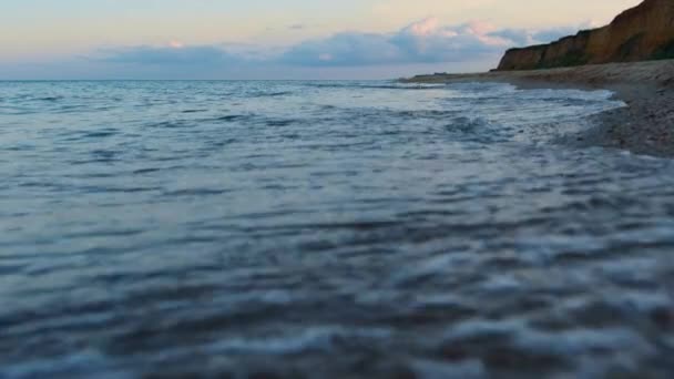 Ondas de água do mar salpicando costa rochosa ao pôr do sol céu nublado. Viagem de relaxamento — Vídeo de Stock