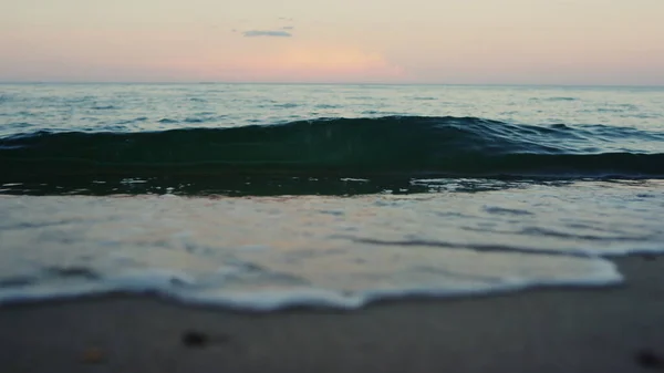 Mavi deniz dalgaları kumsal kıyılarını kırıyor yaz sabahı ağır çekimde. — Stok fotoğraf