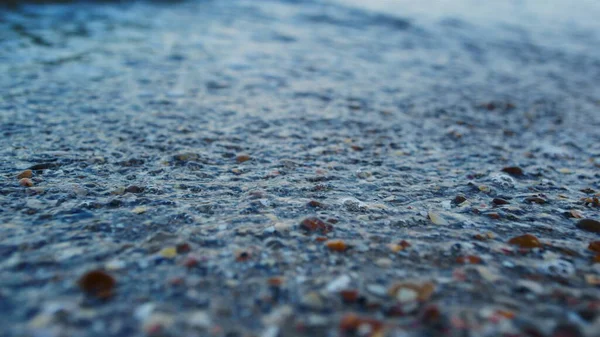 Macro blu acqua di mare spruzzi di conchiglia spiaggia di sabbia al rallentatore. Onde marine — Foto Stock