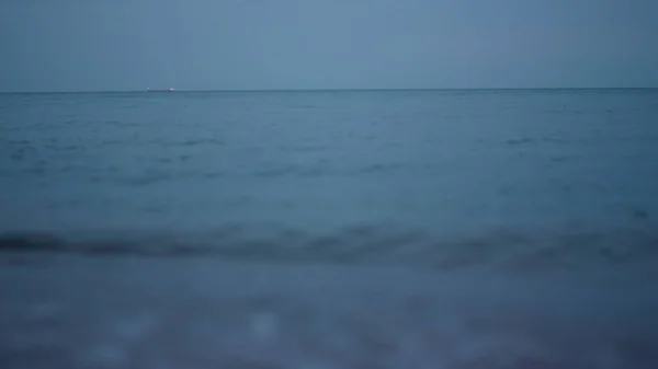 Późnowieczorny pejzaż morski przeciwko błękitnemu niebu zachodu słońca. Uspokajająca piana wodna. — Zdjęcie stockowe