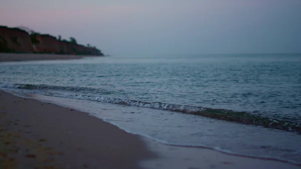 Vista panoramica onde del mare spruzzi spiaggia di sabbia costa in tempo freddo alba — Foto Stock