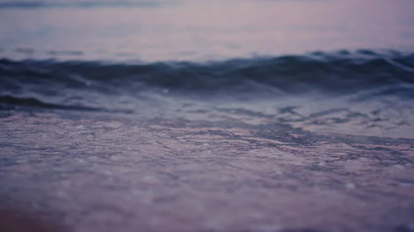 Onde oceaniche spruzzano spiaggia sabbiosa al rallentatore. Acqua di mare che ondeggia sulla spiaggia di sabbia — Foto Stock