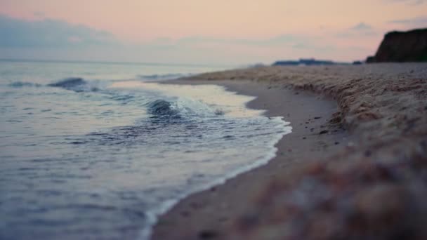 Peaceful rocky hill coastline view at morning sunrise pink sky. Vagues d'eau de mer — Video