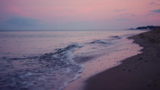 Lila ég tükröződik a tenger felszínén hideg esti naplementekor. Nyugodt hullámok — Stock videók