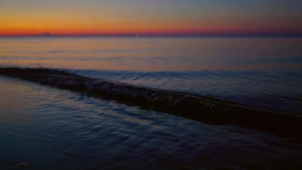 Közelről tenger hullámok fröccsenő sötét homokos strandon. Golden skyline horizont nézet — Stock videók