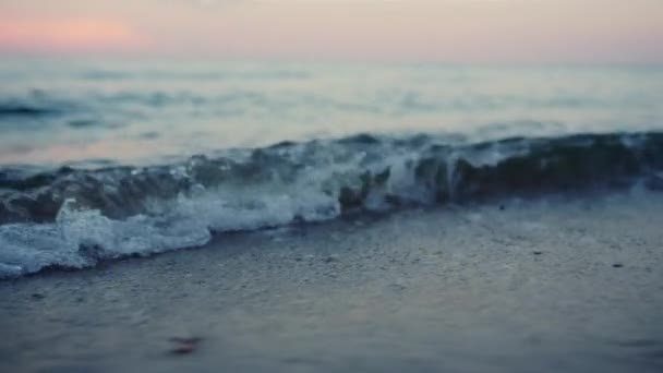 Olas azules del mar salpicando arena en la orilla del mar al amanecer frío de la mañana. Calma el agua del océano — Vídeos de Stock
