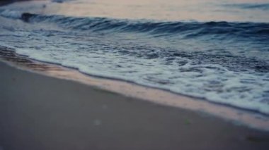 Sabahın köründe kumlu kumsalda dalgalar kopuyor.