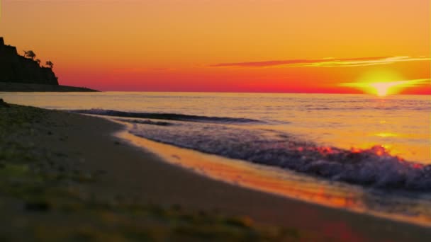 Panorama-Felsensilhouette bei orangefarbenem Sonnenaufgang. Meereswelle — Stockvideo