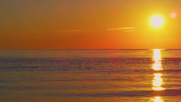 Vista tranquilla del sole arancione che riflette in acqua cristallina dell'oceano blu sul tramonto. — Video Stock