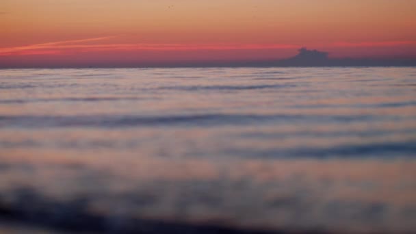 Die Skyline des Meereshorizonts am Morgen des orangen Sonnenaufgangs. Blaue Wellen plätschern am Strand — Stockvideo