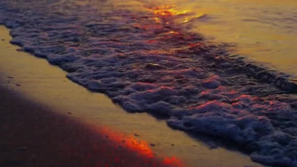 Fechar-se ondas do mar salpicando praia de areia em câmera lenta noite pôr do sol laranja — Vídeo de Stock