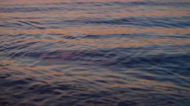 Gros plan surface de l'eau de mer reflétant le ciel violet à l'aube du coucher du soleil soir. — Video