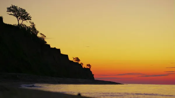 Felsensilhouette mit Bäumen bei goldenem Sonnenaufgang. Sommerlandschaft Meer — Stockfoto