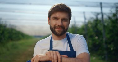 Genç tarımcı, modern güneşli açık hava yeşilliğine bakıyor..