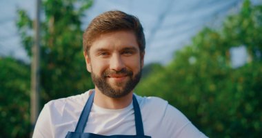 Yaz bahçesinde gülümseyen profesyonel çiftlik işçisi. Mutlu çiftçi pozu.