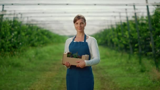 Giovane donna caucasica che tiene scatola di bacche a casa verde albero da frutto. Concetto aziendale. — Video Stock