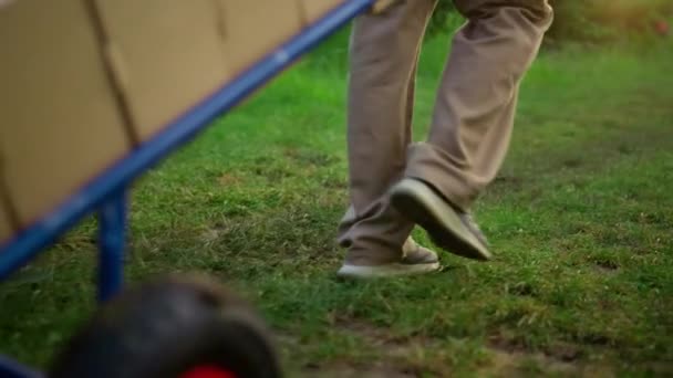 Agronomist nogi spaceru ogród przy użyciu taczki box urządzeń w plantacji. — Wideo stockowe
