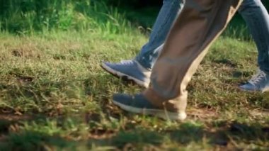 Bahçede yürüyen iki çiftçi bacağı. Ağaç bahçesine giden tarımcılar.