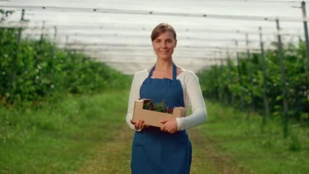 Kvinna trädgårdsmästare tittar kamera på jordbruk modernt växthus på sommaren. — Stockvideo