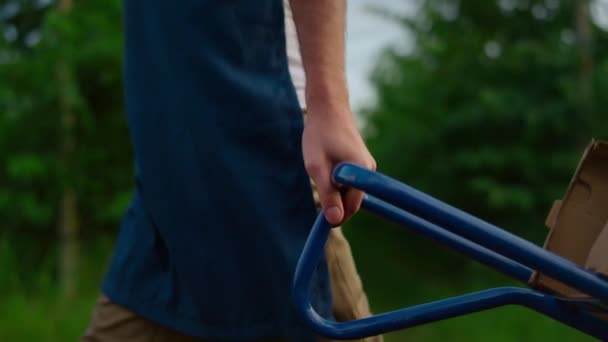 Agricultor que utiliza equipo agrícola. Las manos agrónomas llevan caja de carro en huerto. — Vídeos de Stock