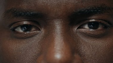 Aşırı yakın plan Afro-Amerikan adam kameraya bakıyor. Afrikalı adam suratı