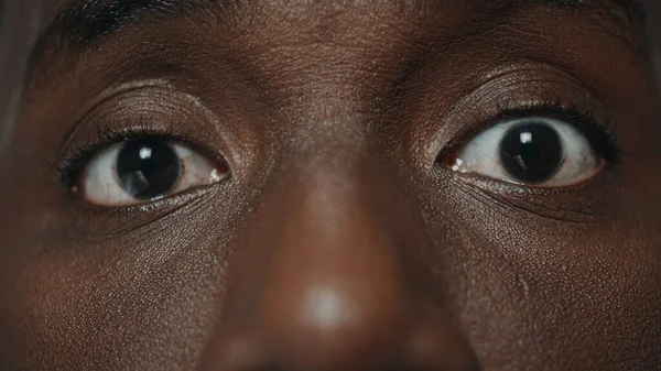 Extrémní detailní záběr překvapil africké americké mužské oči při pohledu do kamery. — Stock fotografie